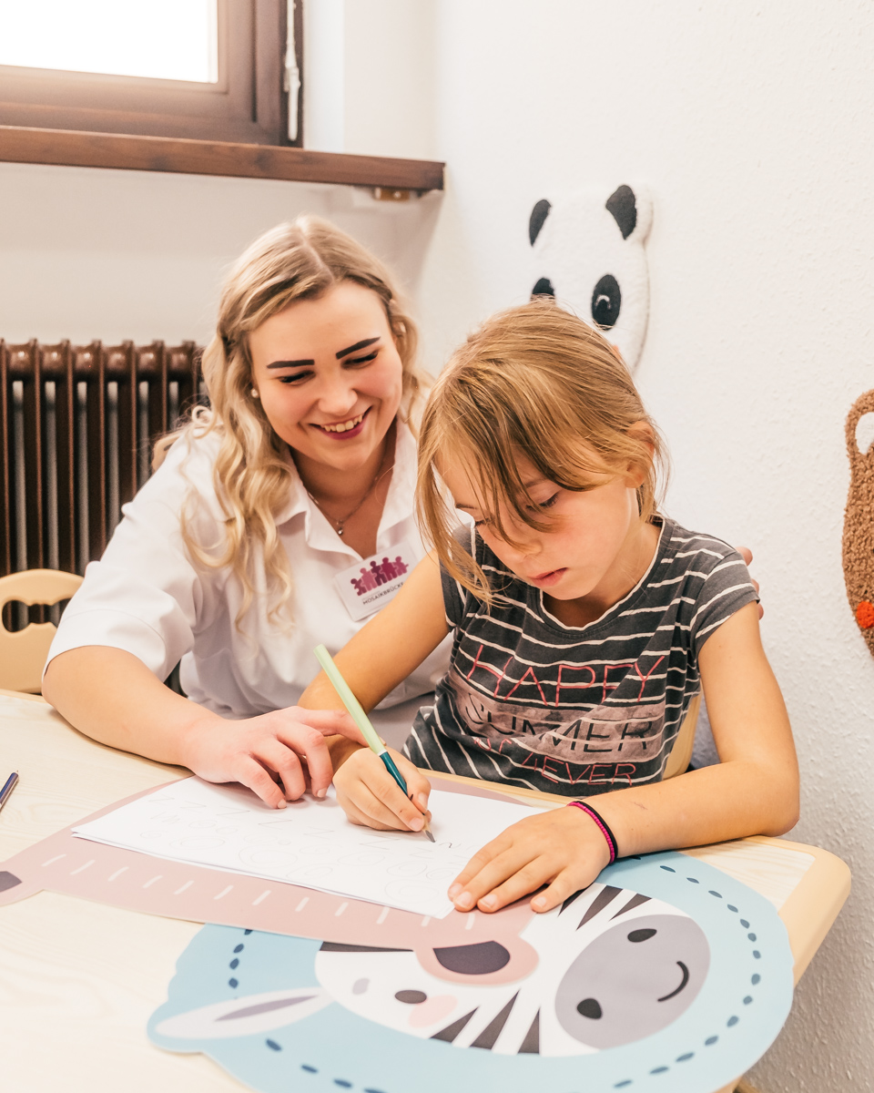 Ergotherapeuting Mareike Grimm im Spiel mit einem Kind während einer Praxisstunde